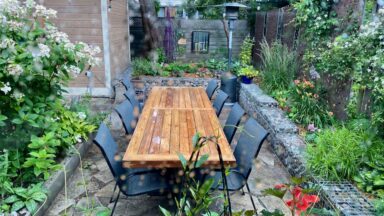 Outdoor dining area defined by gabion cage garden walls